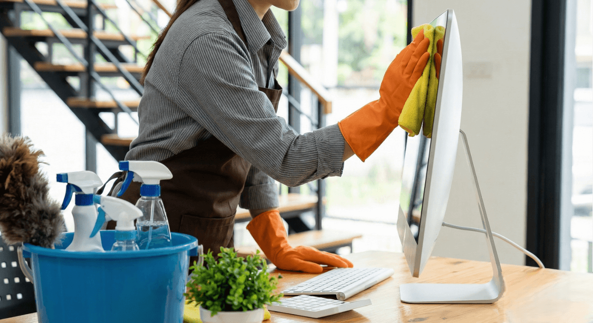 A female cleaner cleaning an office work desk
